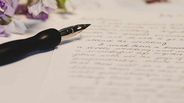 A pen placed on top of a handwritten letter.